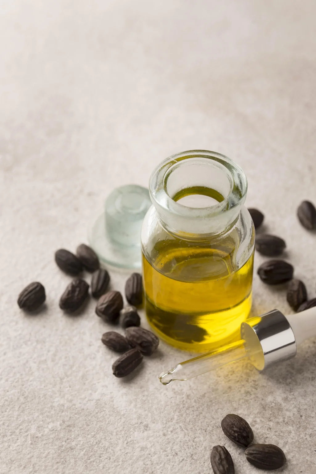 Flacon d’huile de jojoba naturelle avec graines, utilisée pour stimuler la pousse des cheveux et nourrir le cuir chevelu.