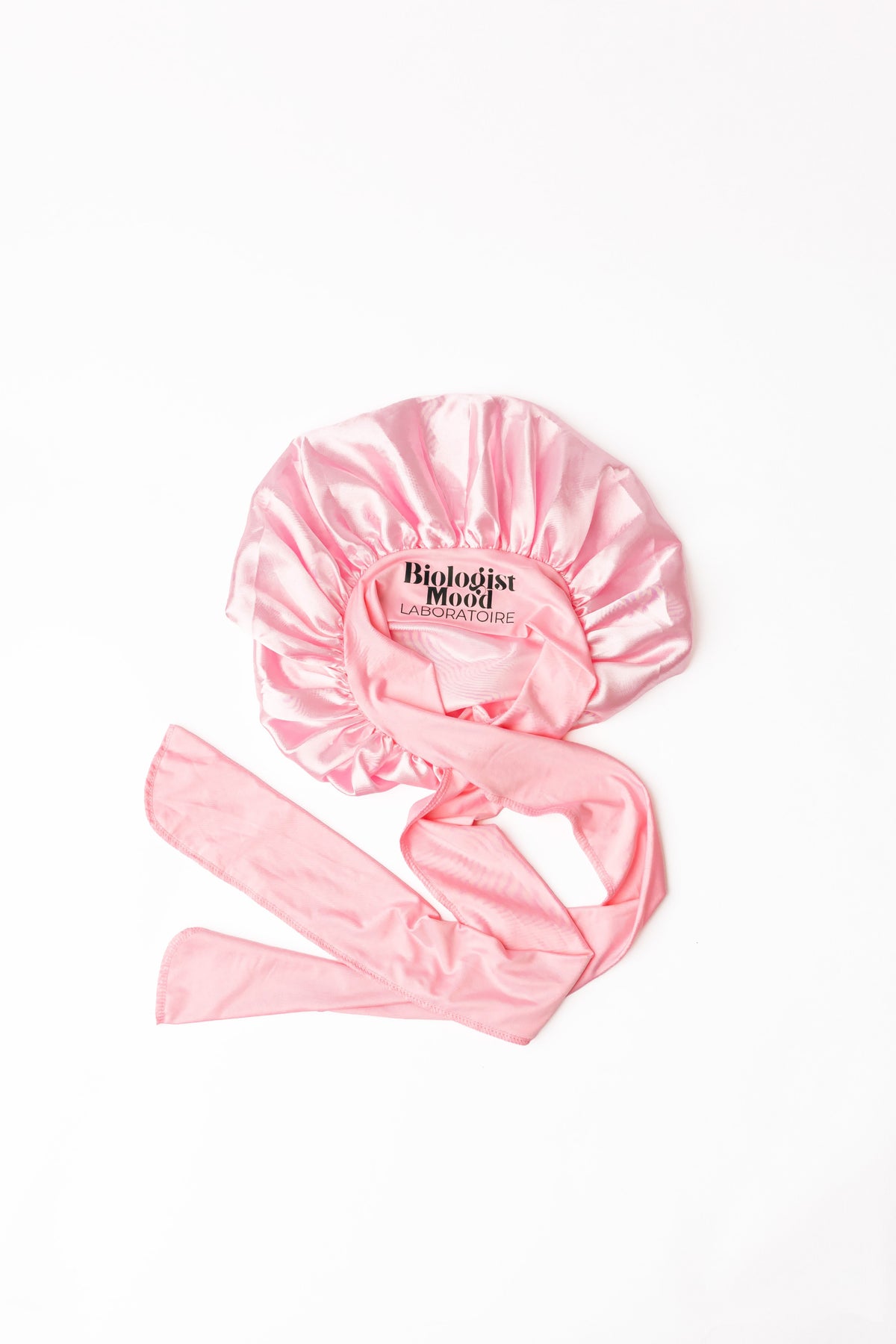 Bonnet en satin rose pour protéger les cheveux pendant la nuit et limiter la casse.