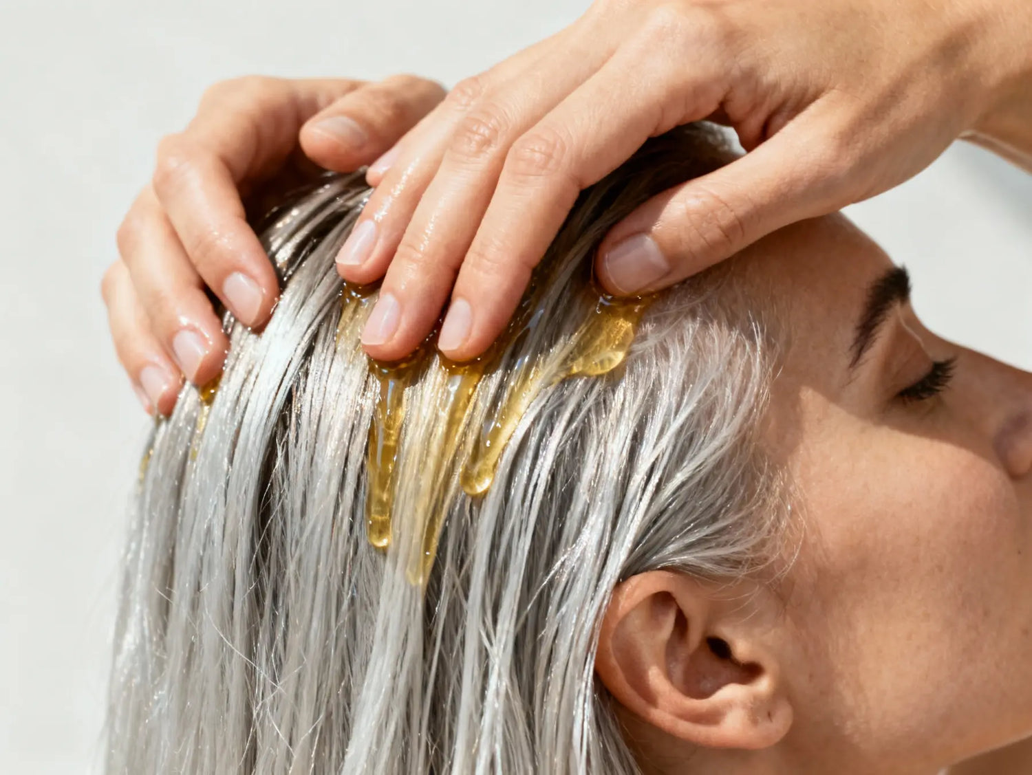 Applying hair growth oil on scalp to stimulate hair growth, strengthen roots and improve hair thickness naturally