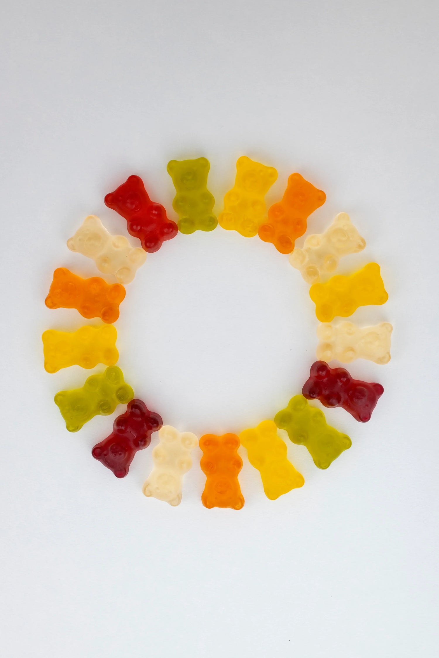 Gummies cheveux multicolores en forme d’oursons disposés en cercle pour illustrer la pousse des cheveux