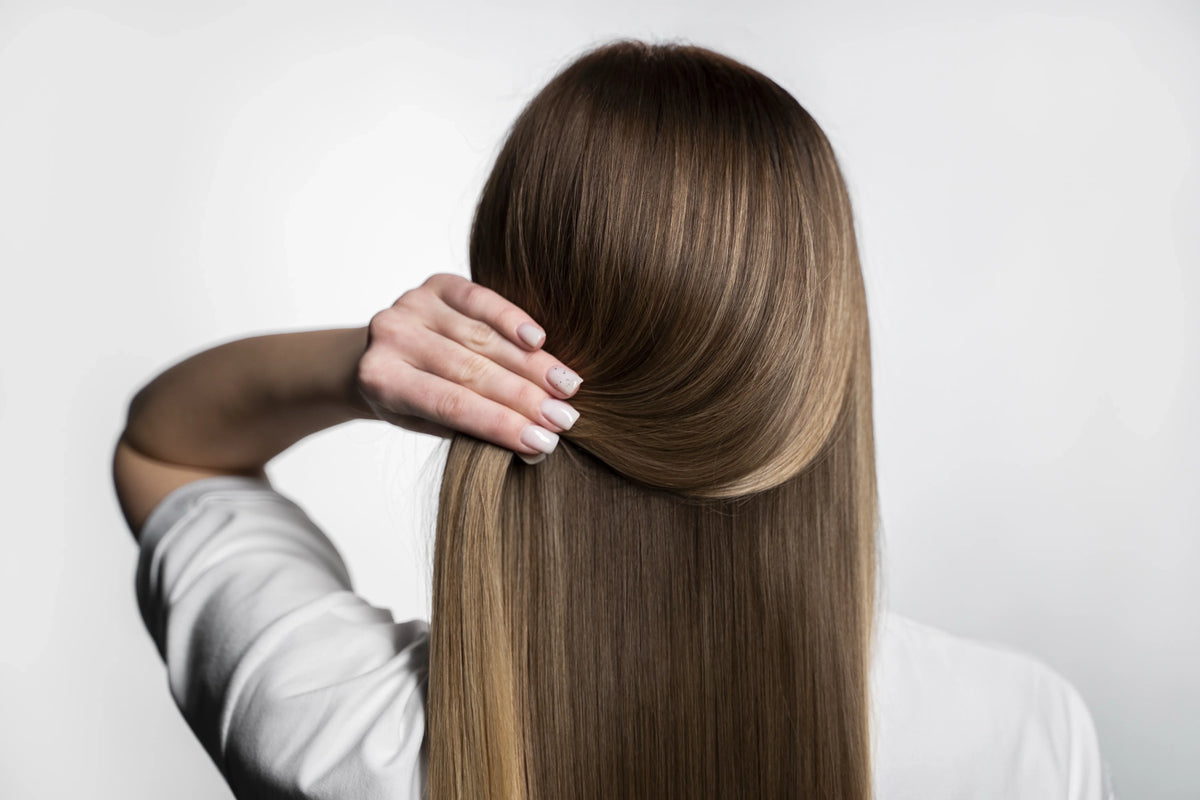 Femme aux cheveux longs et lisses après un lissage brésilien pour une chevelure douce et brillant