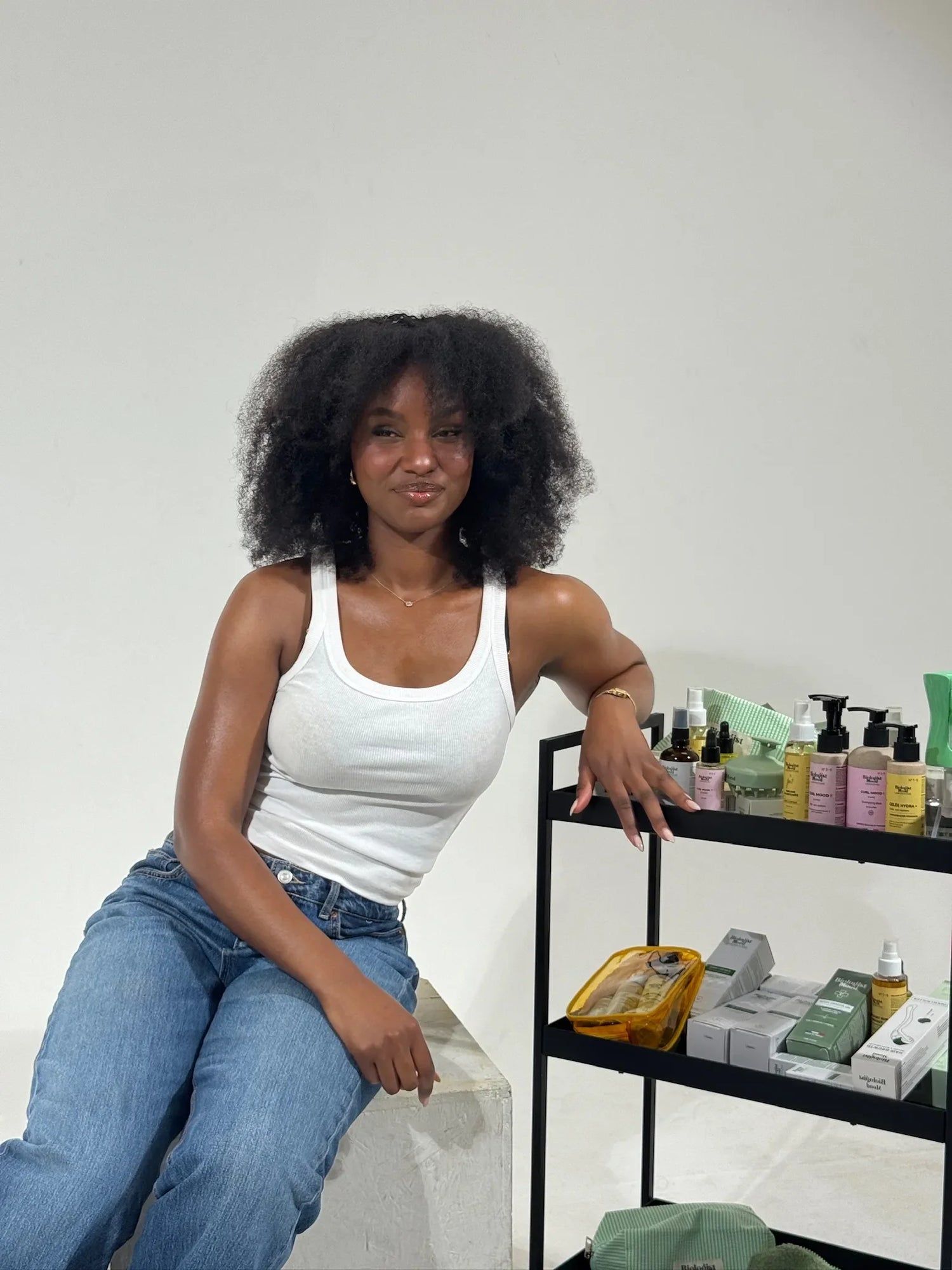 Femme aux cheveux afro avec produits capillaires Biologist Mood pour hydrater et sublimer les cheveux afro