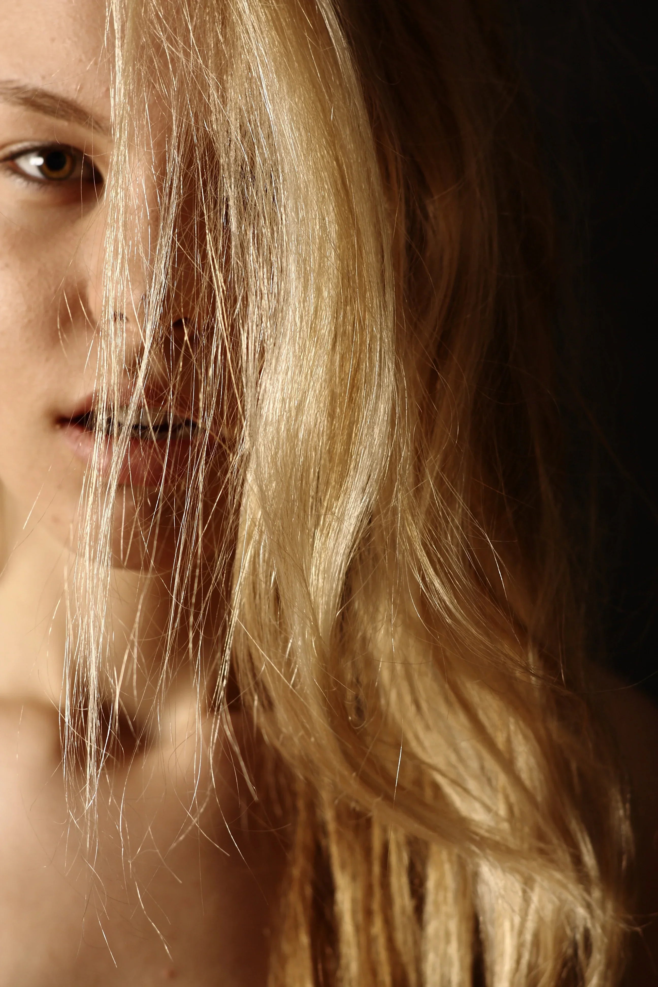 emme aux cheveux blonds soyeux et brillants, symbolisant la vitalité et la santé capillaire.