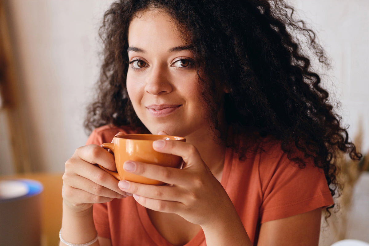 Boucle cheveux naturelle avec une femme aux cheveux bouclés, illustrant une chevelure définie, souple et hydratée