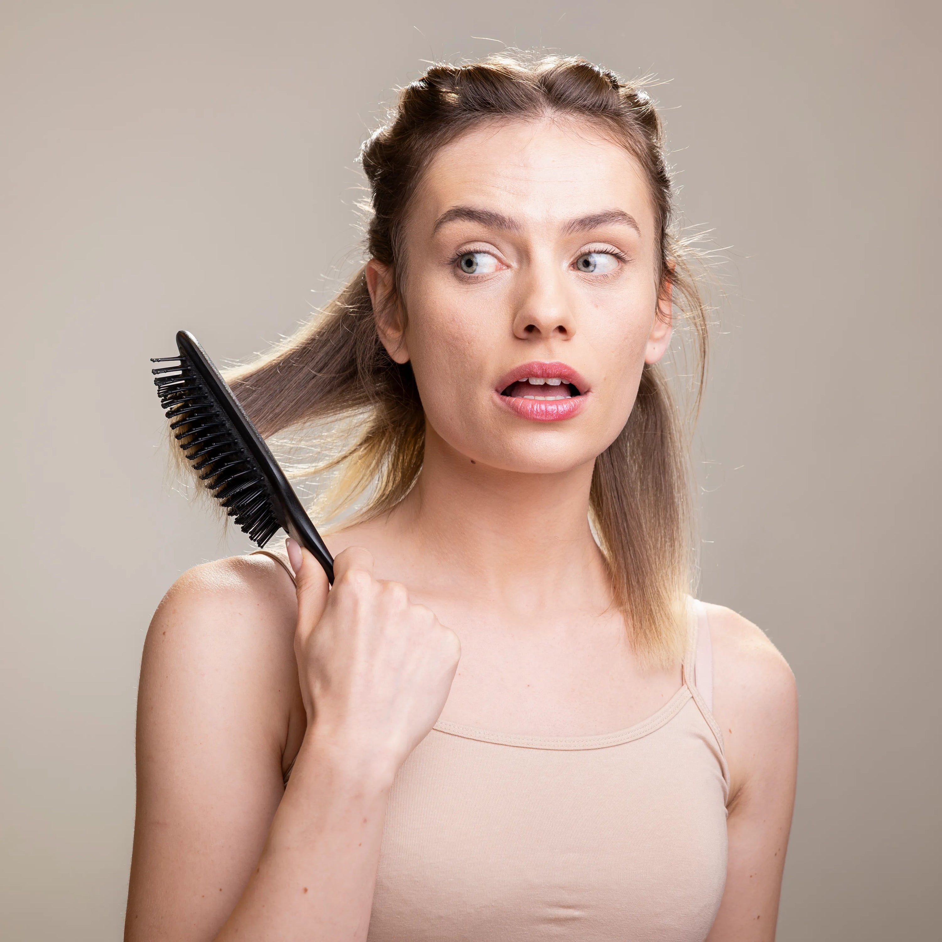 Femme utilisant une brosse pousse cheveux pour stimuler la croissance et prendre soin de sa chevelure