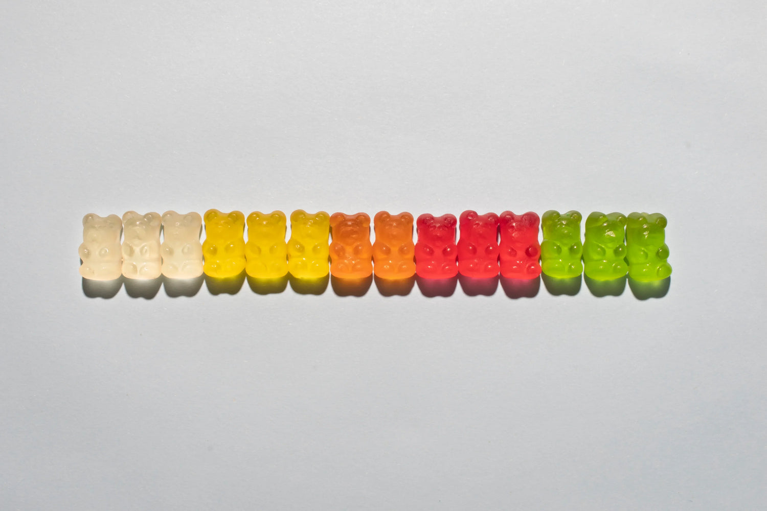 Gummies cheveux colorés illustrant les risques potentiels des compléments alimentaires sucrés pour la pousse des cheveux