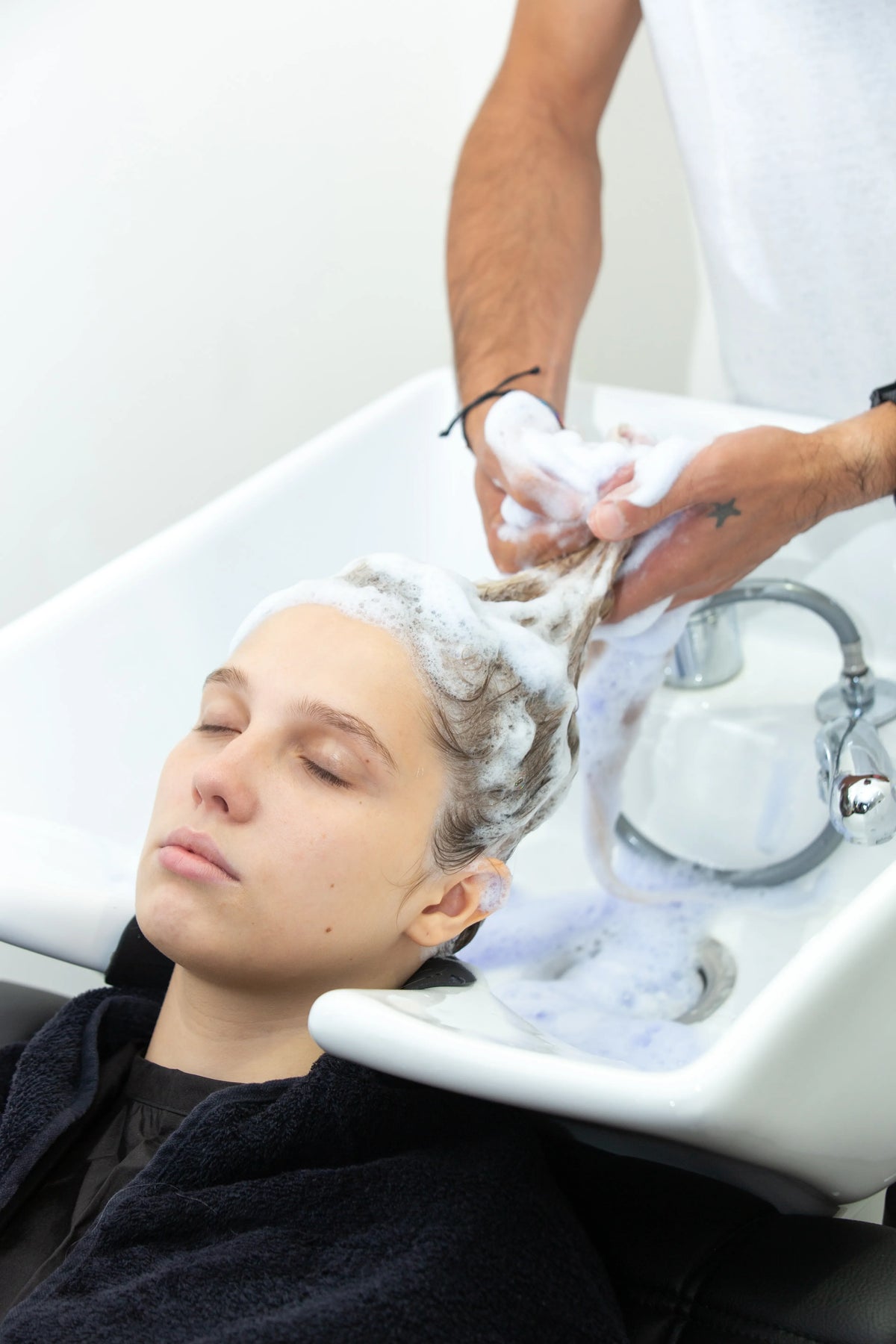 Femme lavant ses cheveux avec un shampoing sans sulfate pour un nettoyage doux du cuir chevelu