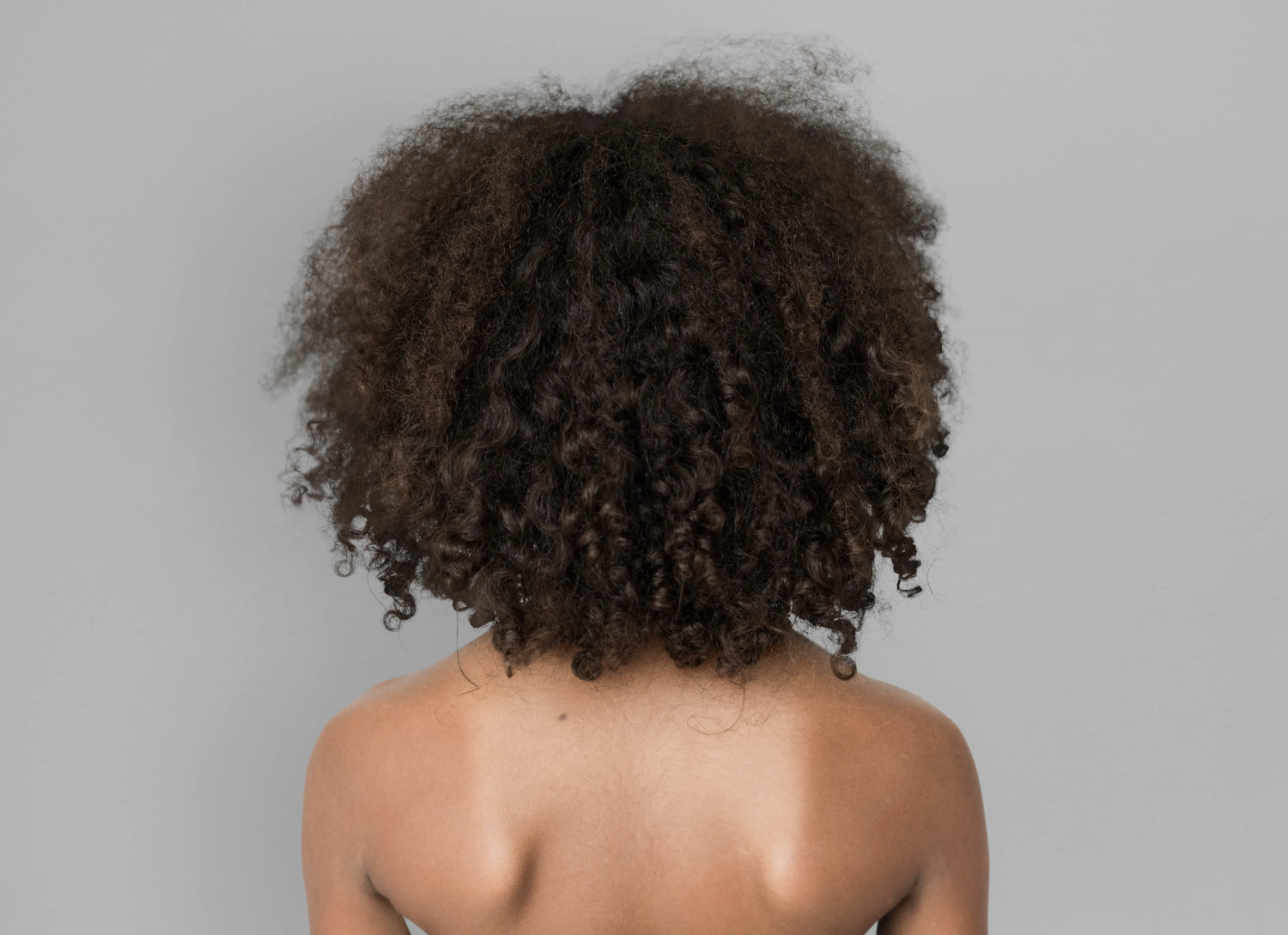 Cheveux afro naturels avec boucles volumineuses et texture crépue pour une routine capillaire adaptée