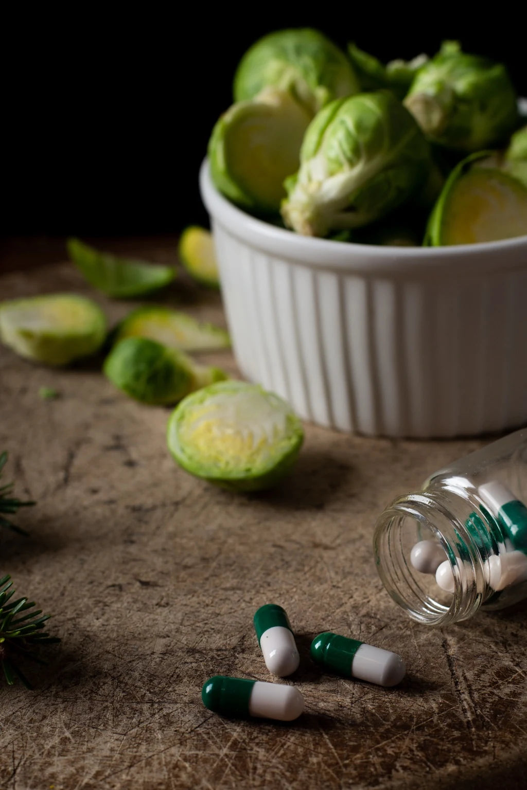 Gélules de complément alimentaire naturel pour la pousse des cheveux Biologist Mood, disposées près de choux de Bruxelles riches en nutriments pour illustrer une nutrition capillaire saine.