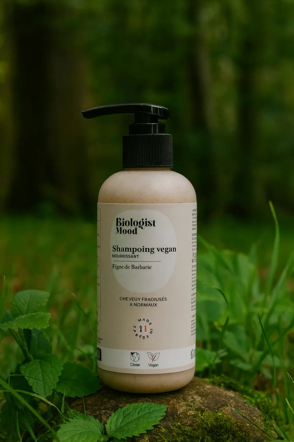  Shampoing vegan à la figue de barbarie Biologist Mood posé sur un fond vert naturel avec feuillage et lumière douce, soin nourrissant pour cheveux fragilisés à normaux.